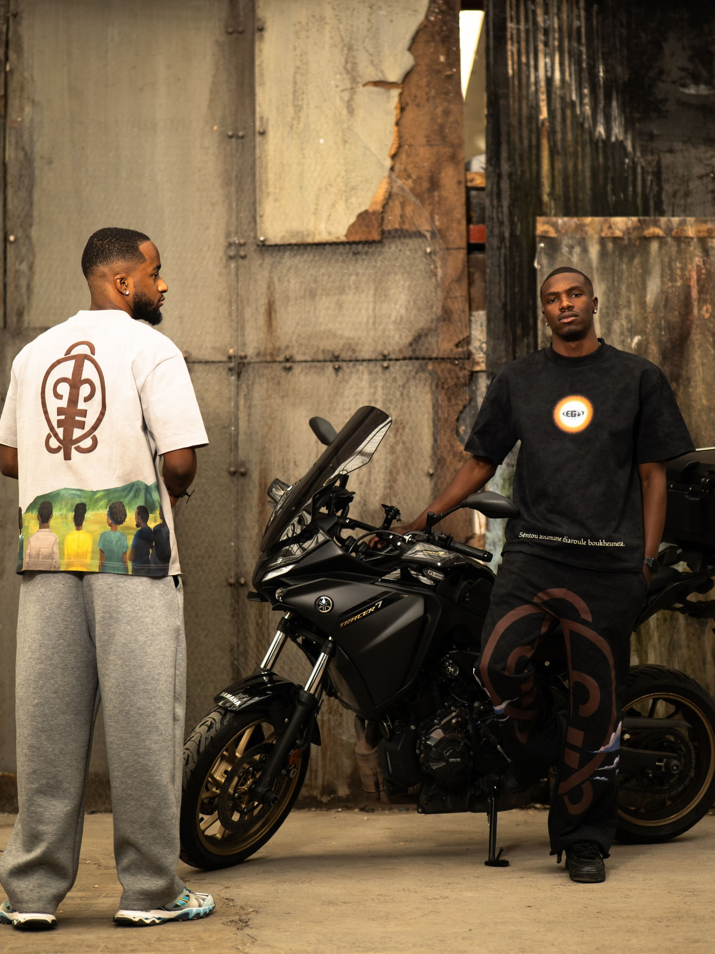 Tee-shirts graphiques et pantalon signature autour d’une moto