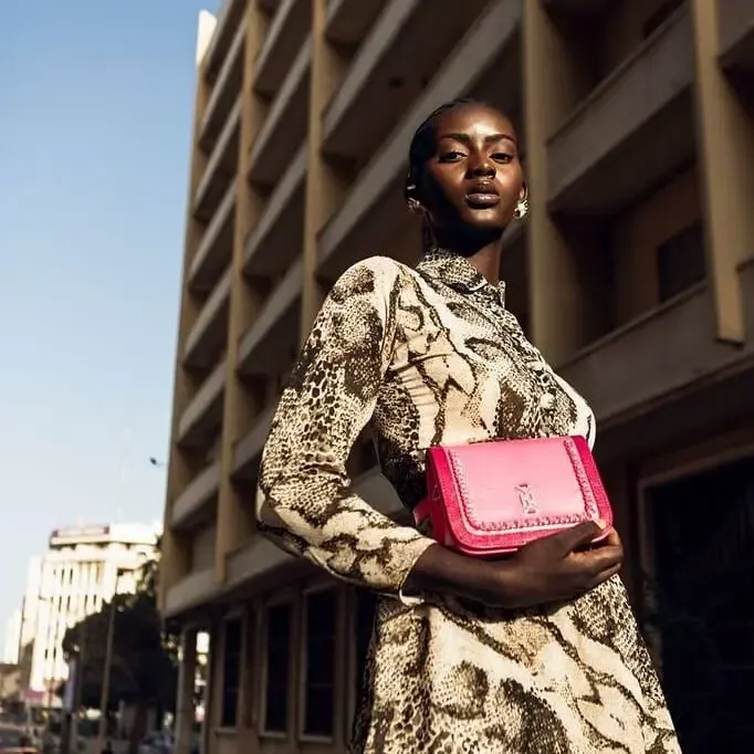Campagne Dakar — sac bandoulière fuchsia porté avec une robe python
