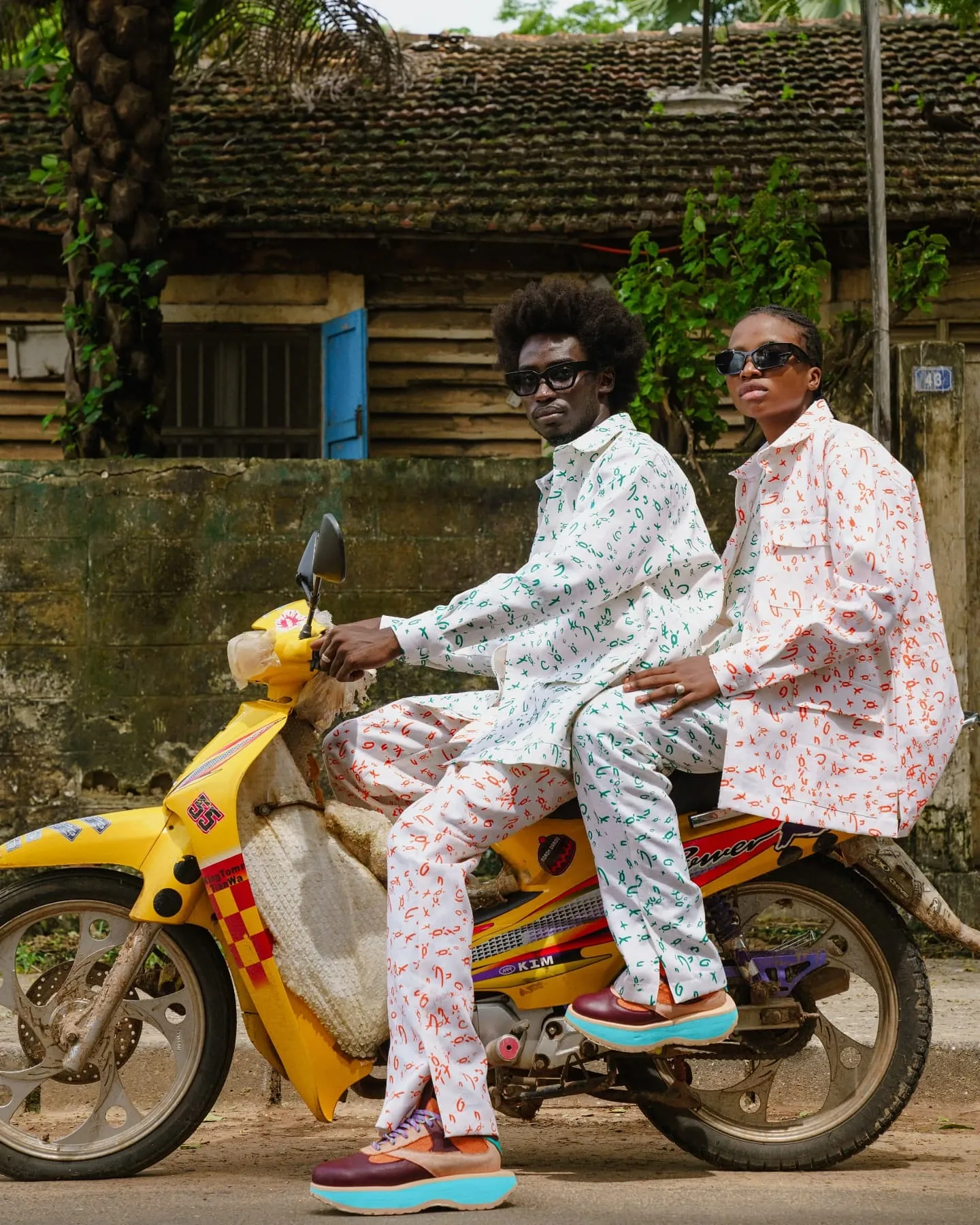 Couple en total look imprimé sur mobylette jaune