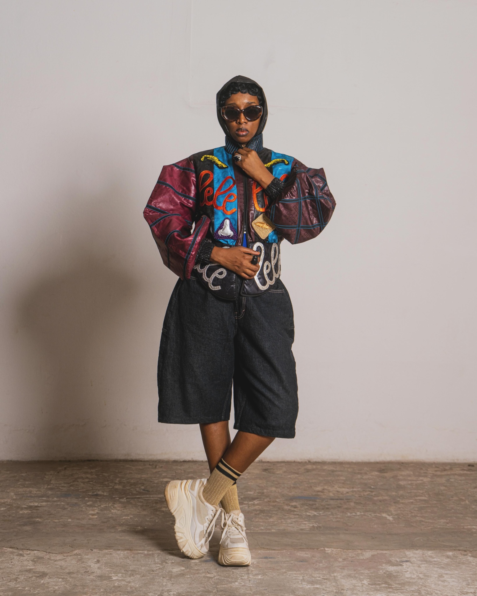 Blouson patchwork brodé « lelele » — bermuda denim et sac banane assorti.