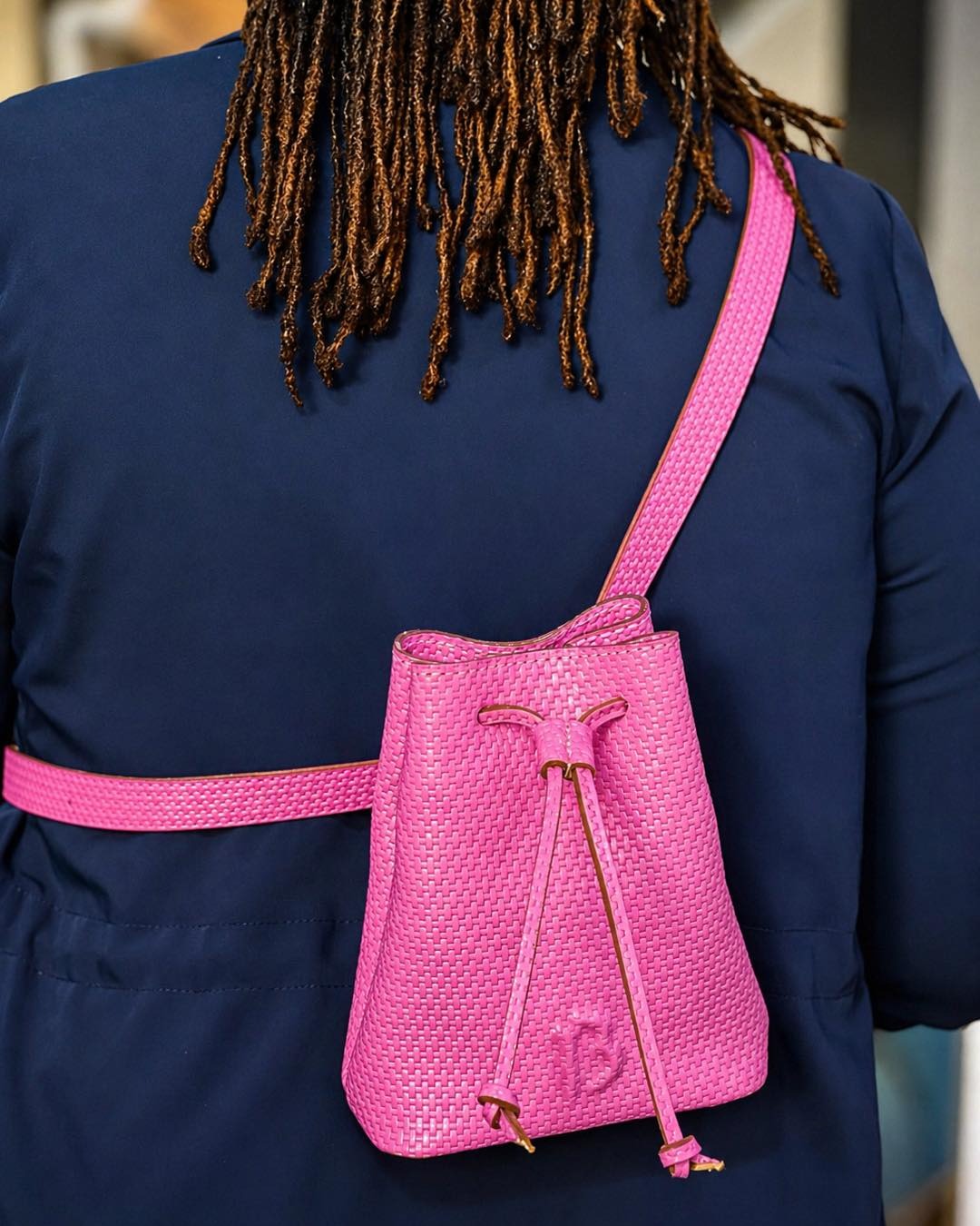 Bucket rose fuchsia — le mini bag signature en bandoulière.
