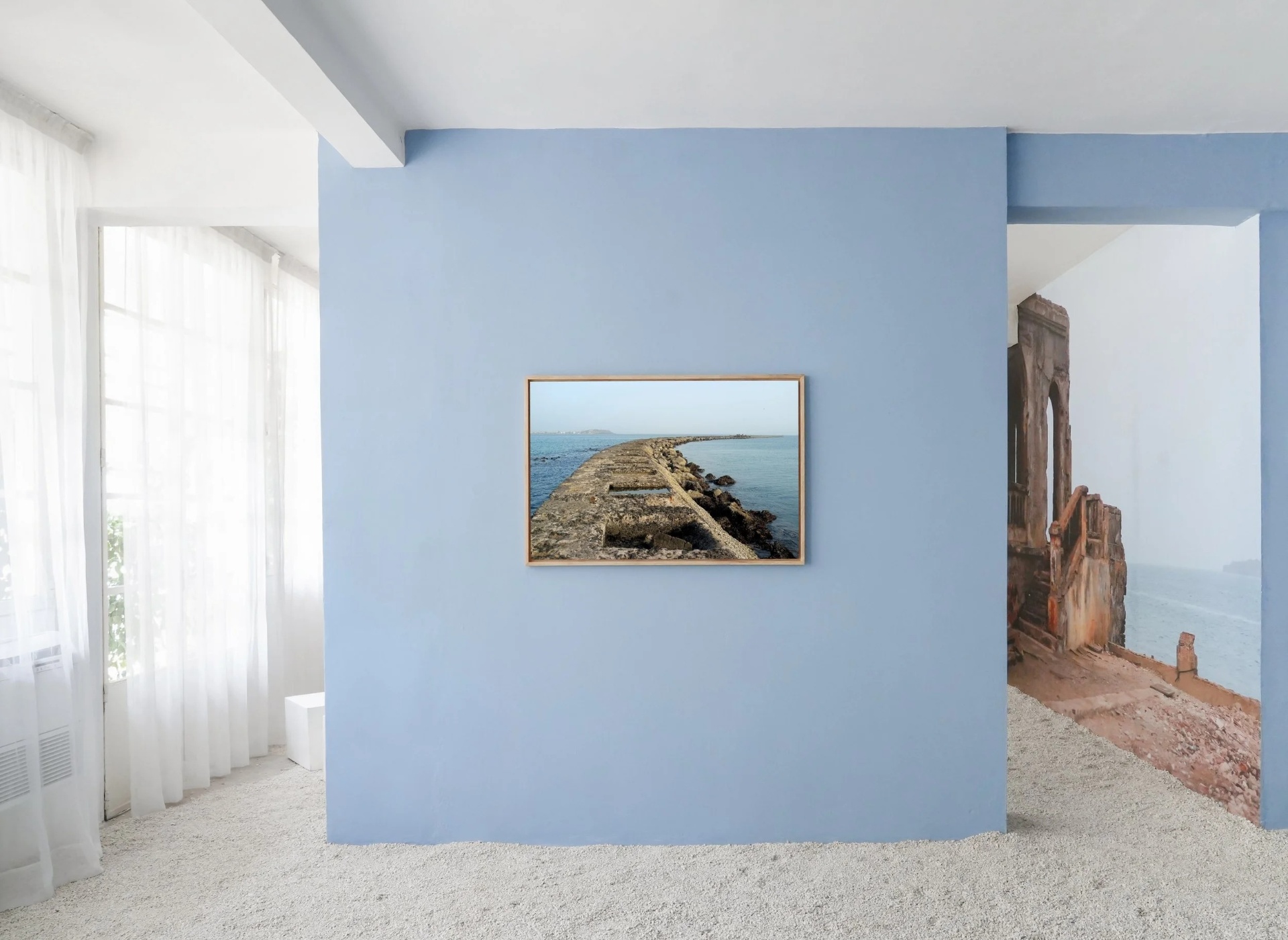 Ibrahima Thiam — Yoonou Ndoke, la voix de l'eau : scénographie bleu ciel et ruines de bord de mer.