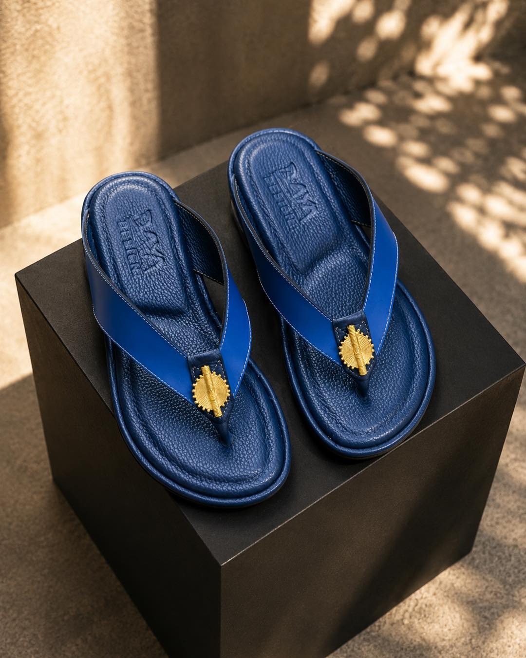 Tong en cuir bleu roi, bouton filigrane doré — l'élégance nomade.