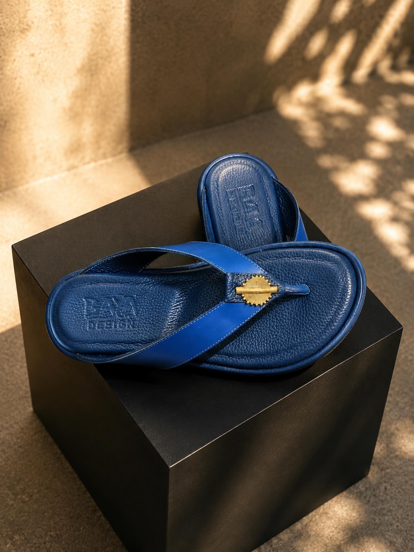 Sandales en cuir bleu roi, médaillon doré.
