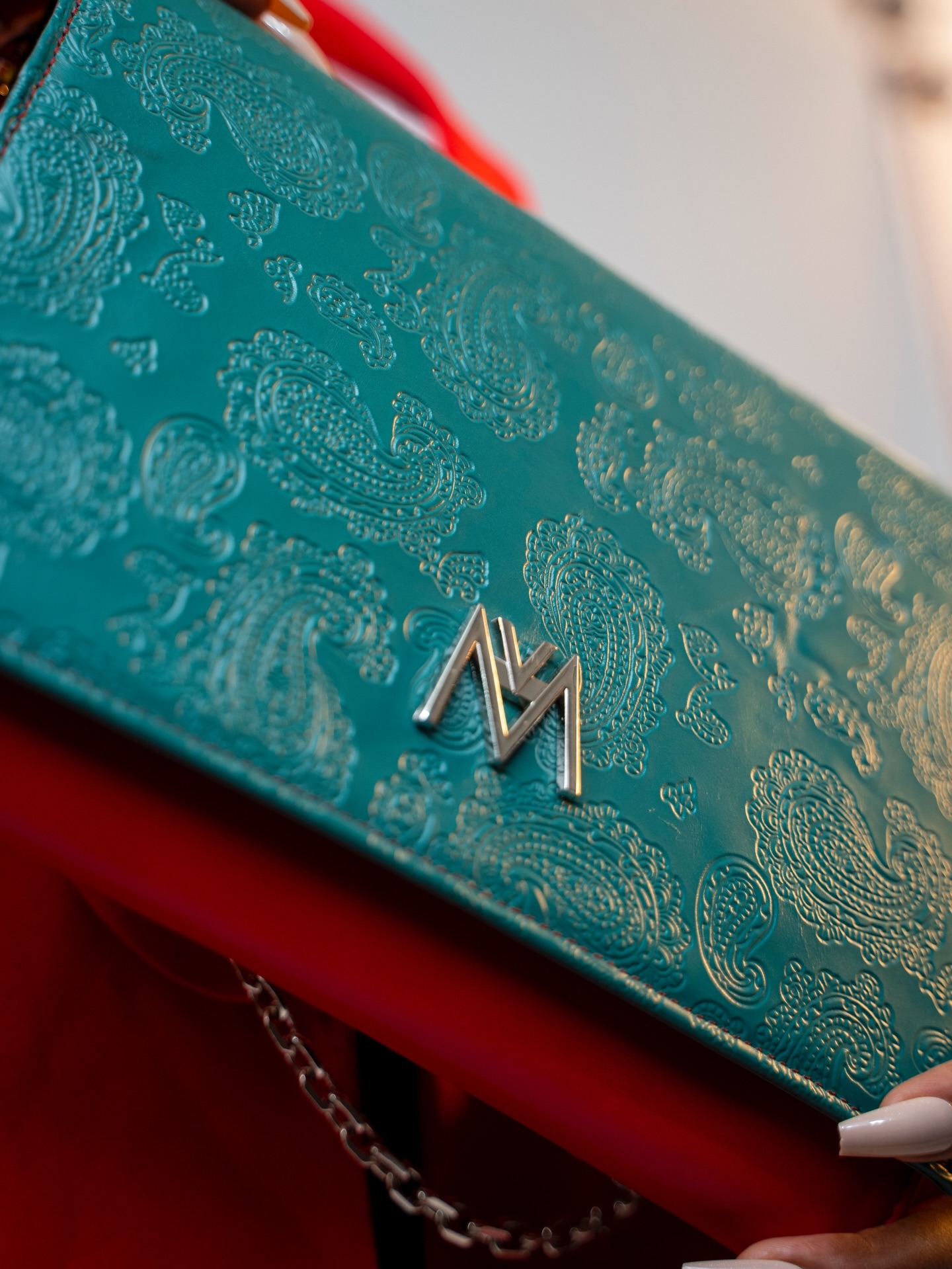 Pochette émeraude — cuir gaufré paisley & M en métal