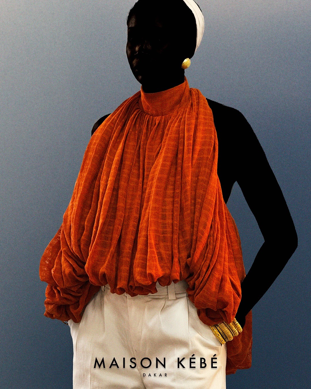 Blouse drapée terracotta et bijoux dorés