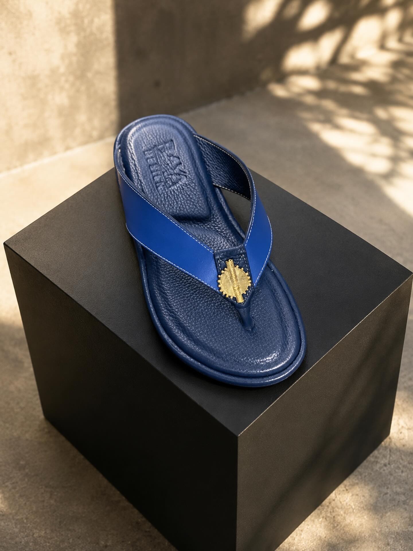 Détail — tong bleu roi, cuir lisse et grainé.