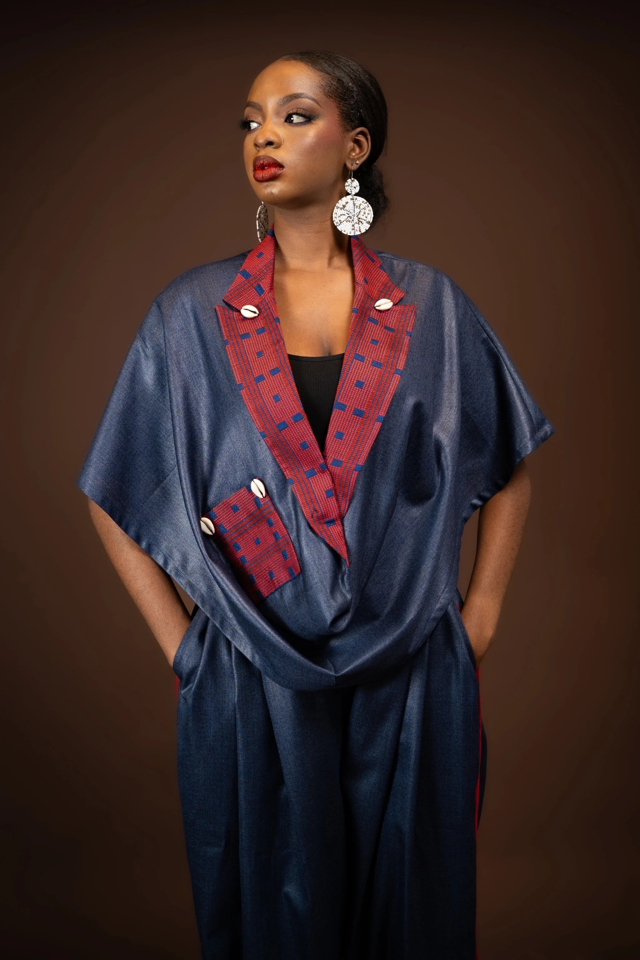 Cape drapée denim — plastron tissé rouge et cauris