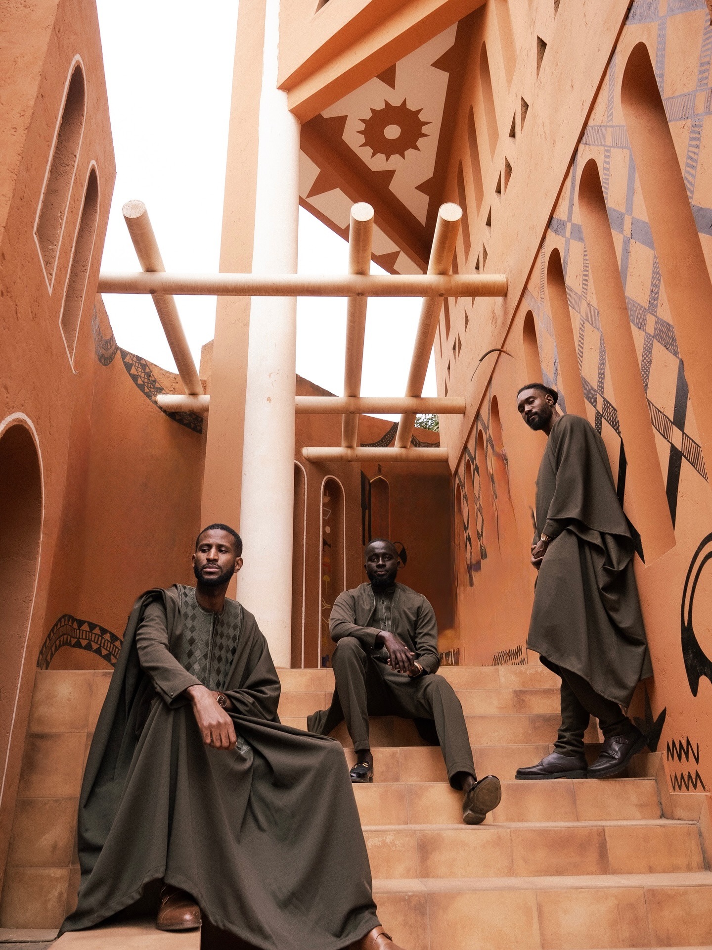 Vestiaire homme kaki — trio dans une cour terracotta ornée