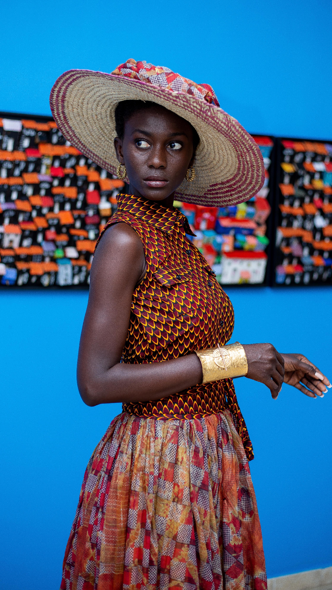 Chapeau tressé et robe wax écailles — galerie fond bleu