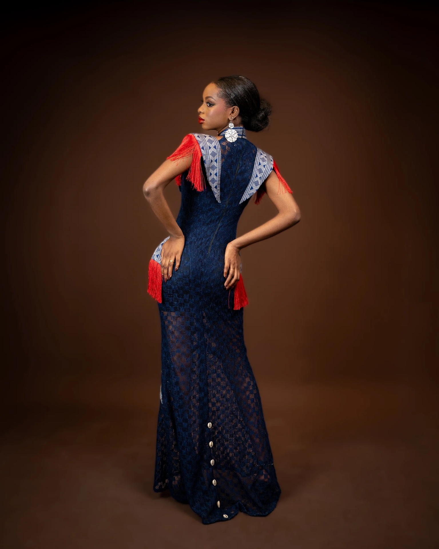 Dos travaillé — dentelle indigo, franges rouges et cauris