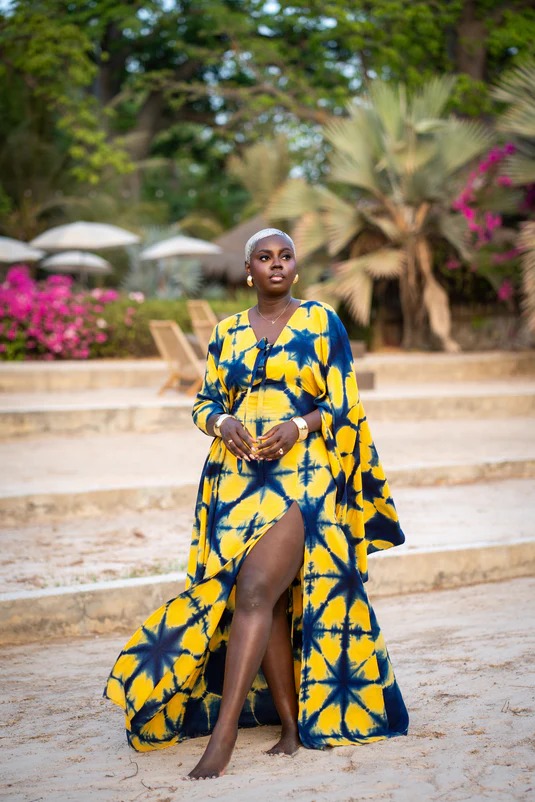 Robe longue tie-dye jaune et bleu — silhouette solaire face à la mer.
