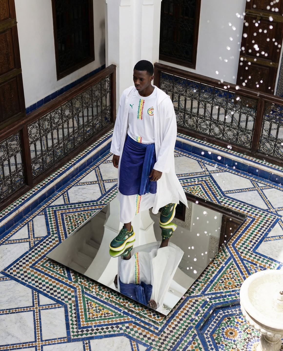 Riad marocain — silhouette réfléchie dans un miroir zellige