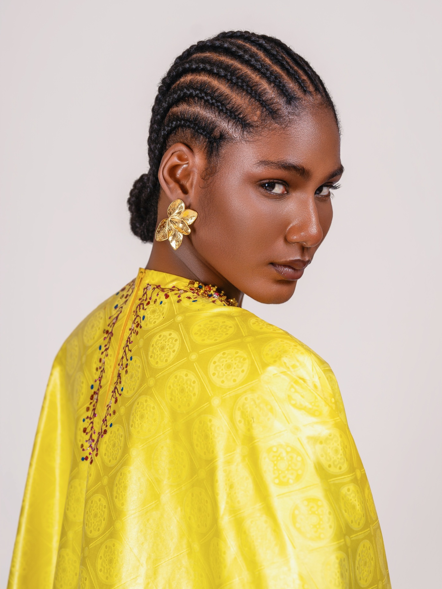 Détail dos — bazin jaune et tresses